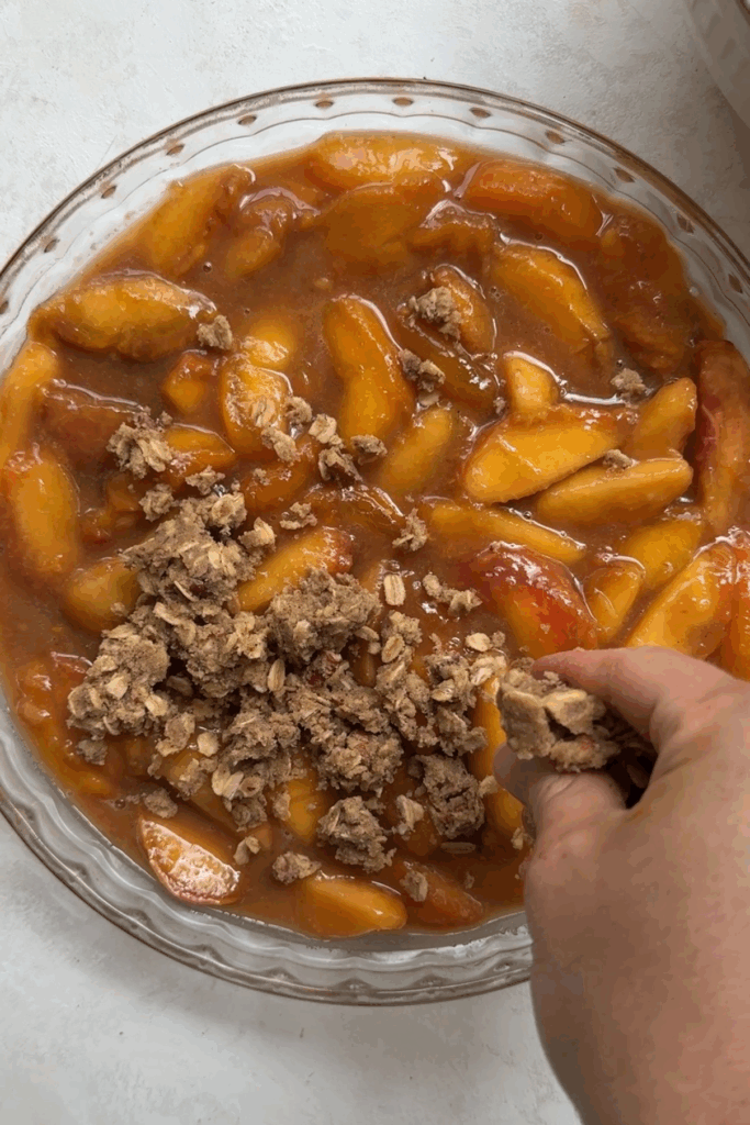 adding topping to peaches