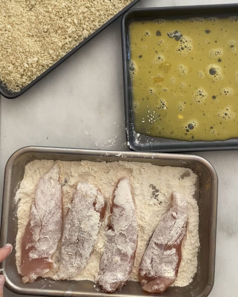 tossing chicken in flour
