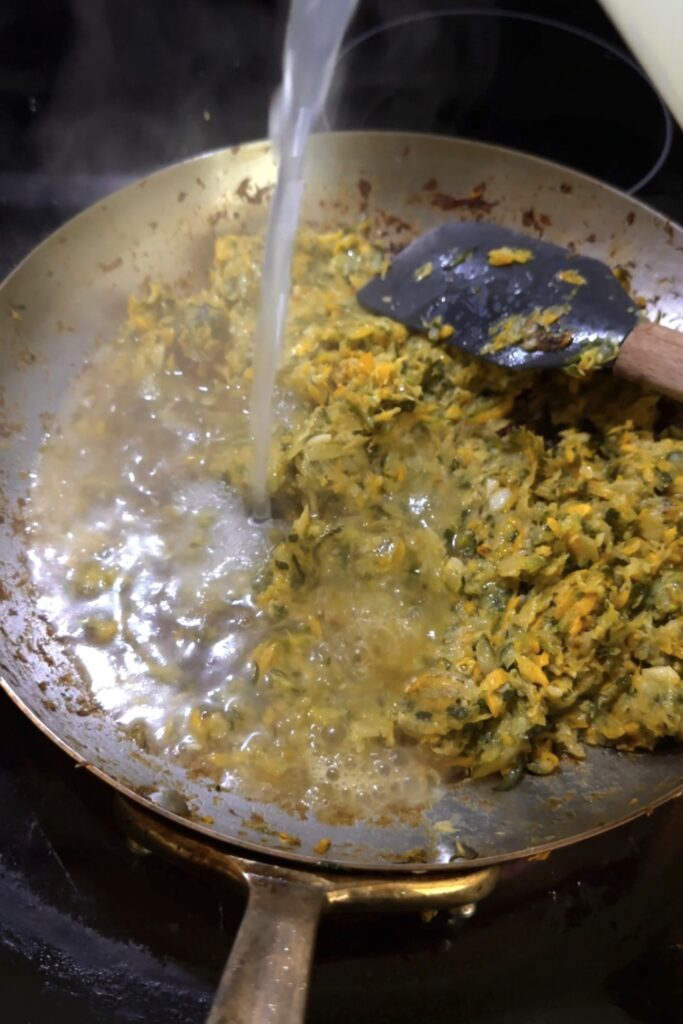 adding pasta water to cooked zucchini
