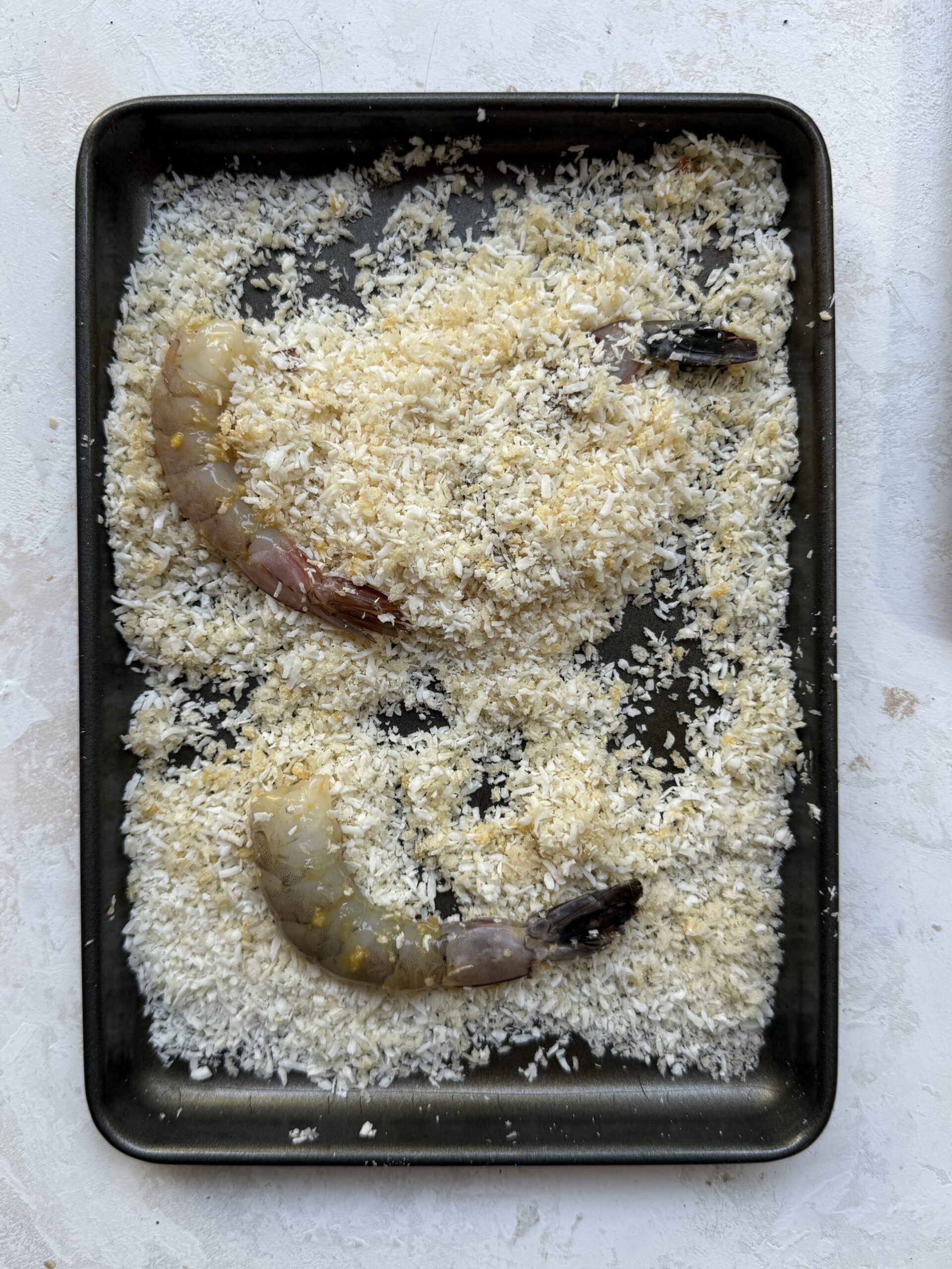 Shrimp coated in panko breadcrumbs and shredded coconut before frying.